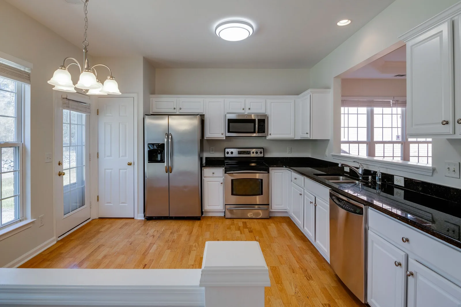 Kitchen with white cabinetry, granite counters and stainless appliances